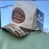 Person wearing a cap with a logo against a clear sky